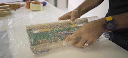 Man wrapping timber climbing tool in bubble wrap